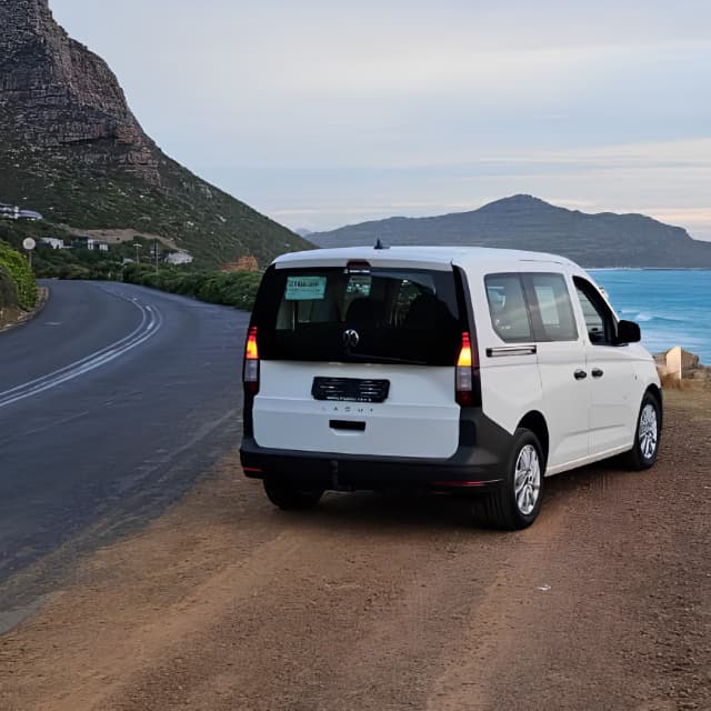 Cape Town chauffeur vehicle parked along a coastal mountain road, reinforcing the focus on safe and professionally planned transport.